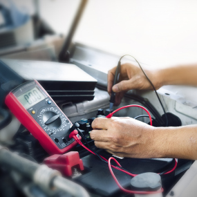 Ein Mechaniker testet eine Autobatterie (Symbolbild).