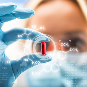 Eine Wissenschaftlerin prüft eine rote Pille (Symbolbild).